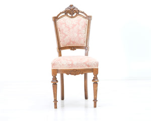 Antiikkinen tuoli vaaleanpunaisella verhoilulla