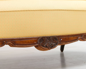 Antiikkinen sohva keltaisella verhoilulla